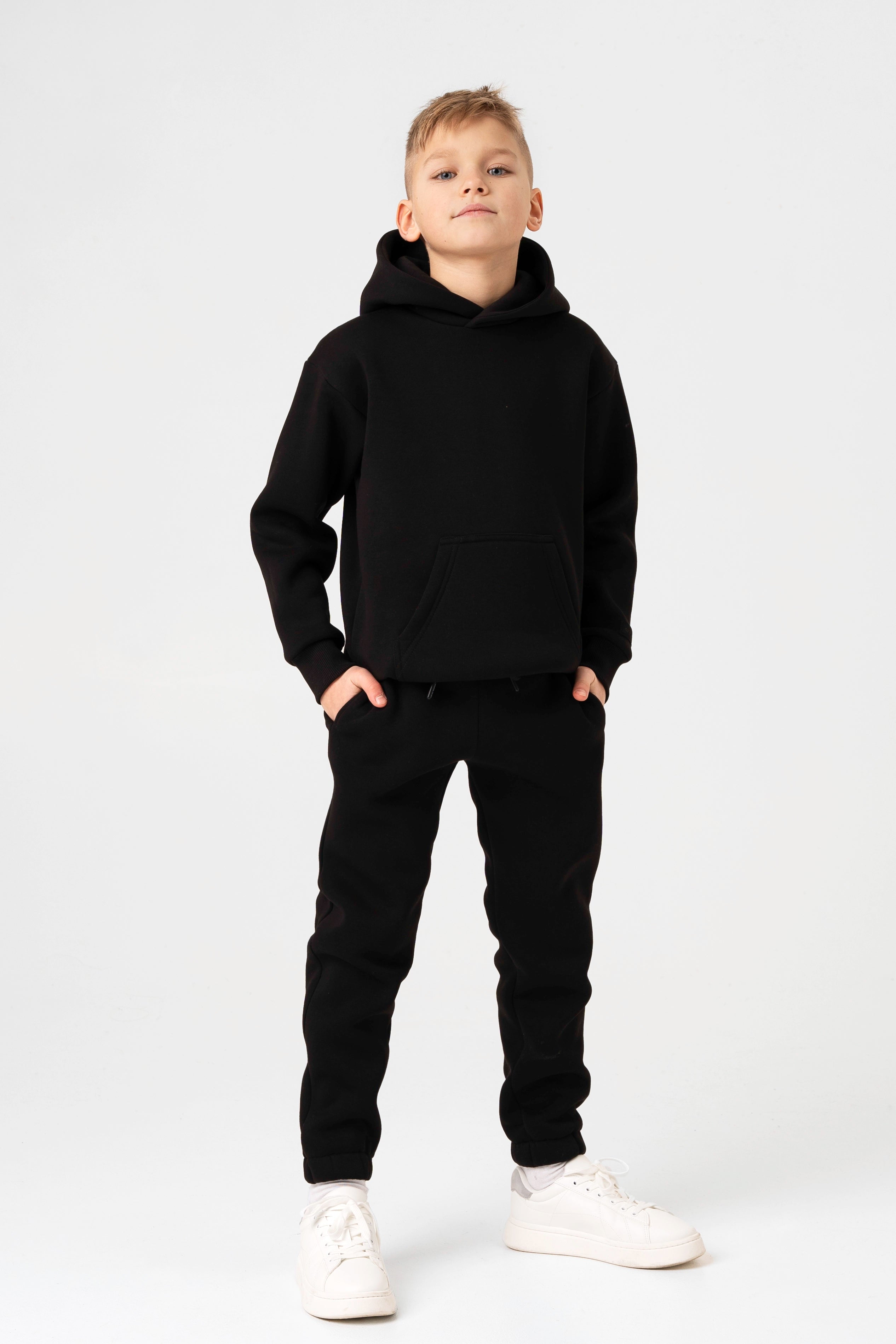 Juodi unisex vaikiški treningai – džemperis su kišene ir kelnės su raišteliais juosmenyje.