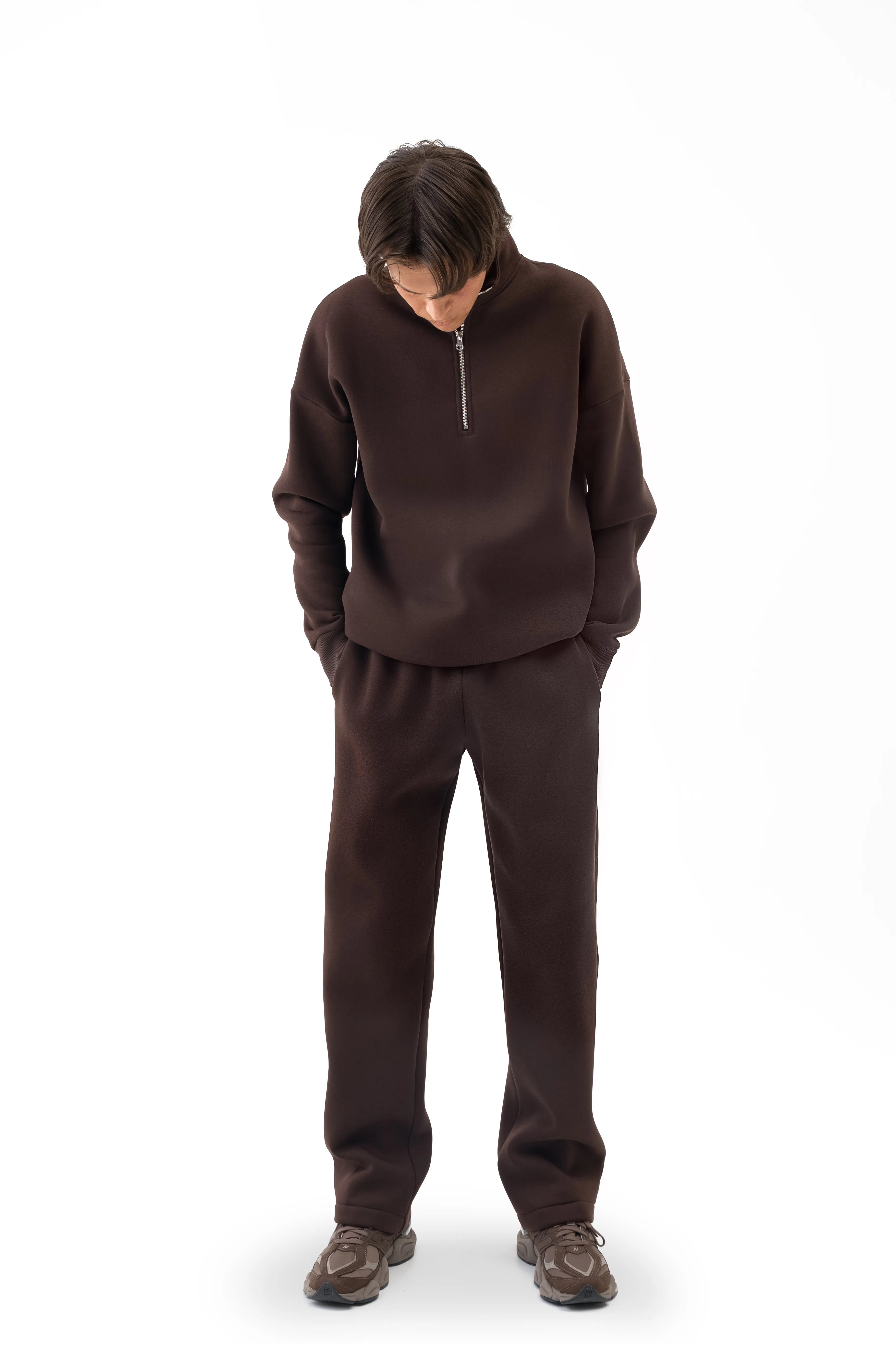 Vyriškas rudas laisvalaikio kostiumėlis su tiesiomis kelnėmis ir aukšta apykakle, modelis žiūri žemyn