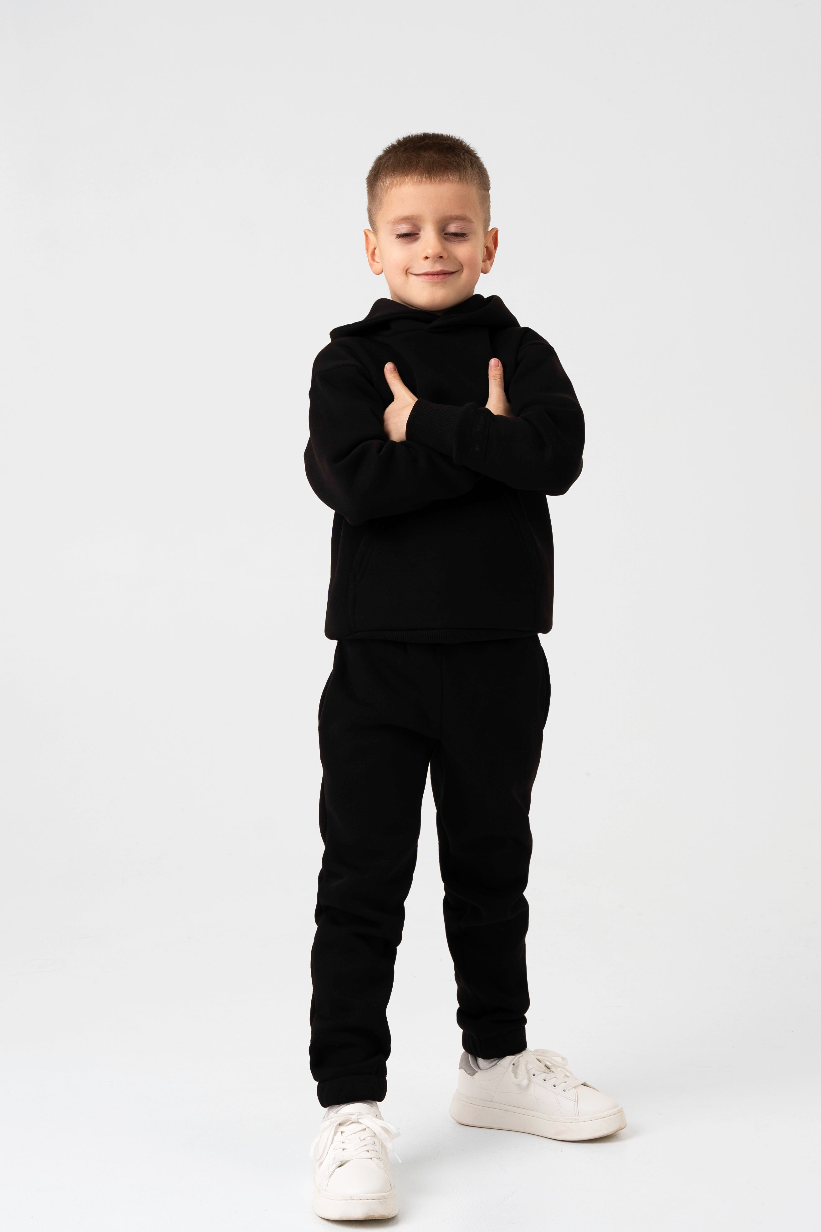 Patogūs laisvalaikio treningai vaikams – juodos spalvos, su kišenėmis ir minkštu audiniu.