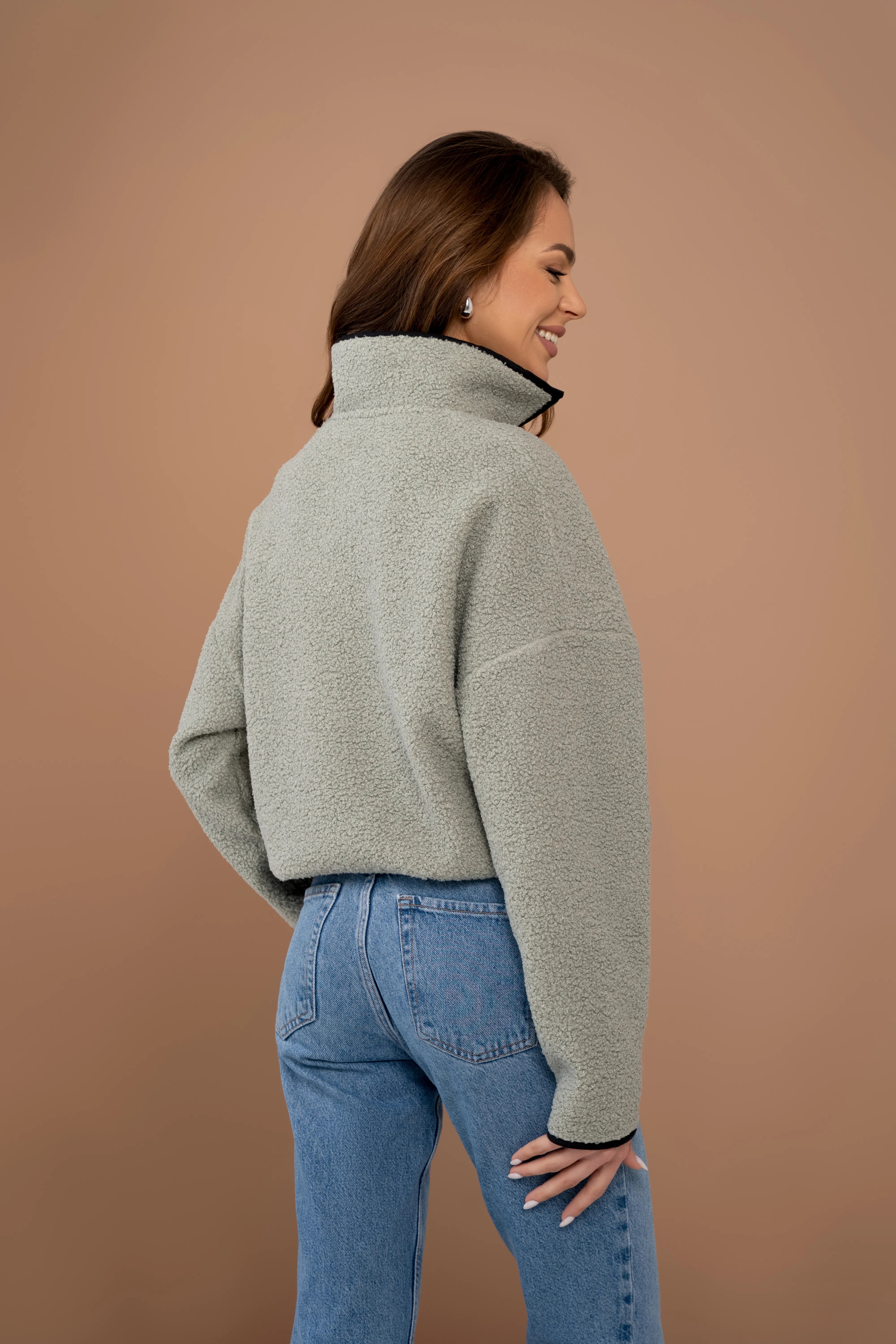 Women’s khaki jumper from the back with a stand-up collar, long sleeves, and a straight back line