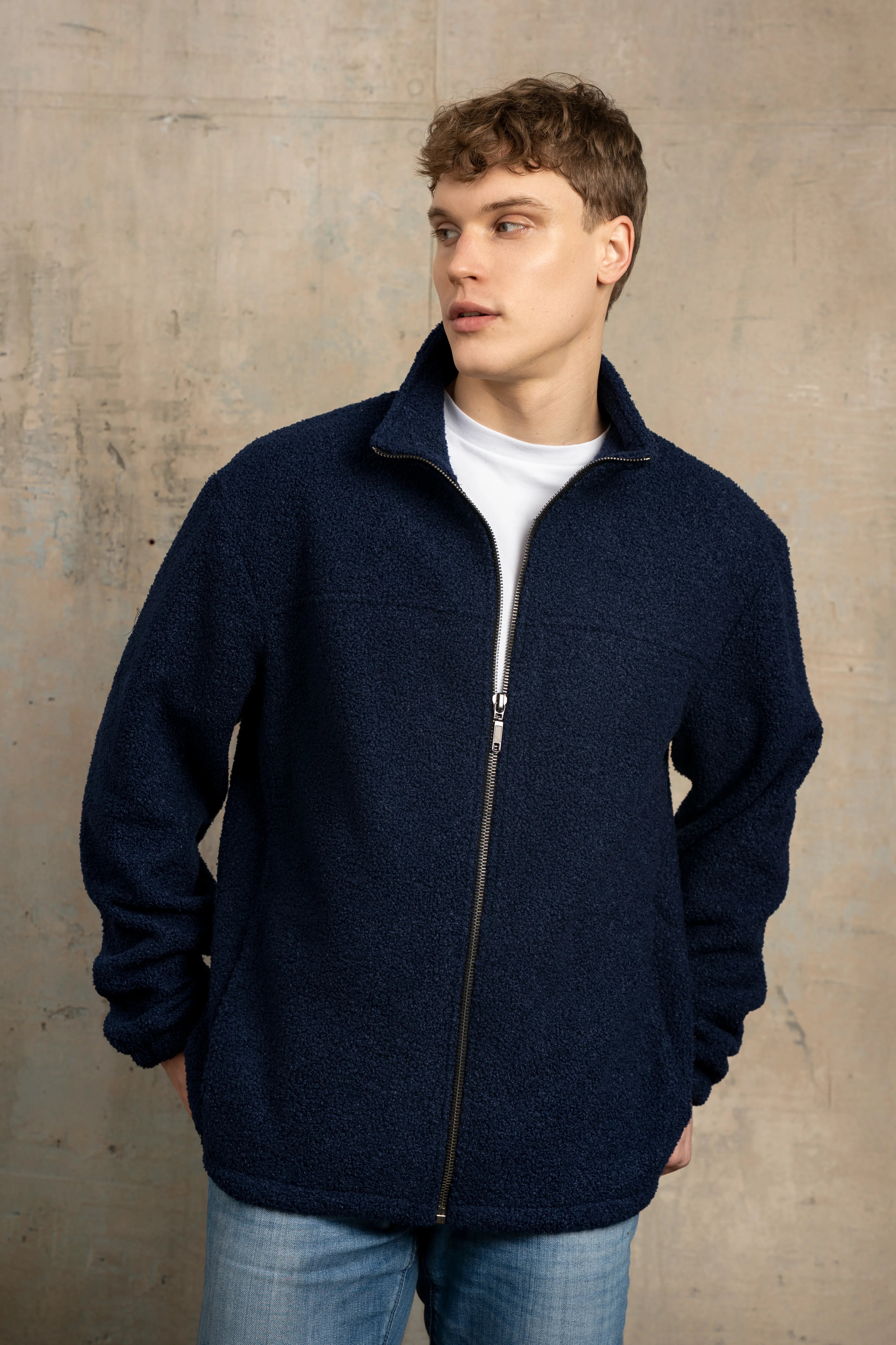 Tamsiai mėlynos spalvos vyriškas džemperis su pilno ilgio užtrauktuku, stačia apykakle, ilgomis rankovėmis ir vaizdu iš priekio