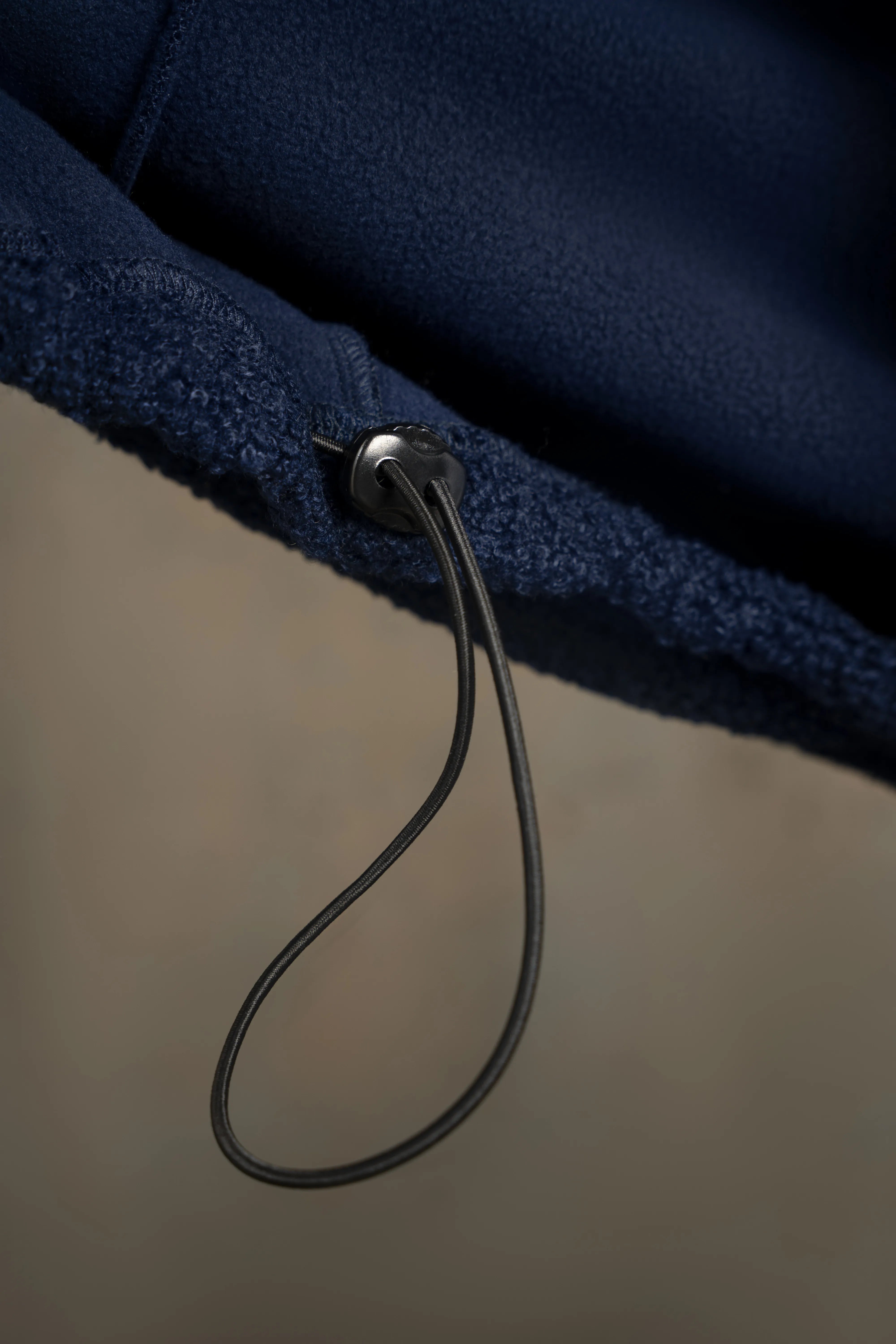 Detail of the bottom drawstring and seam on the dark navy men’s sweatshirt