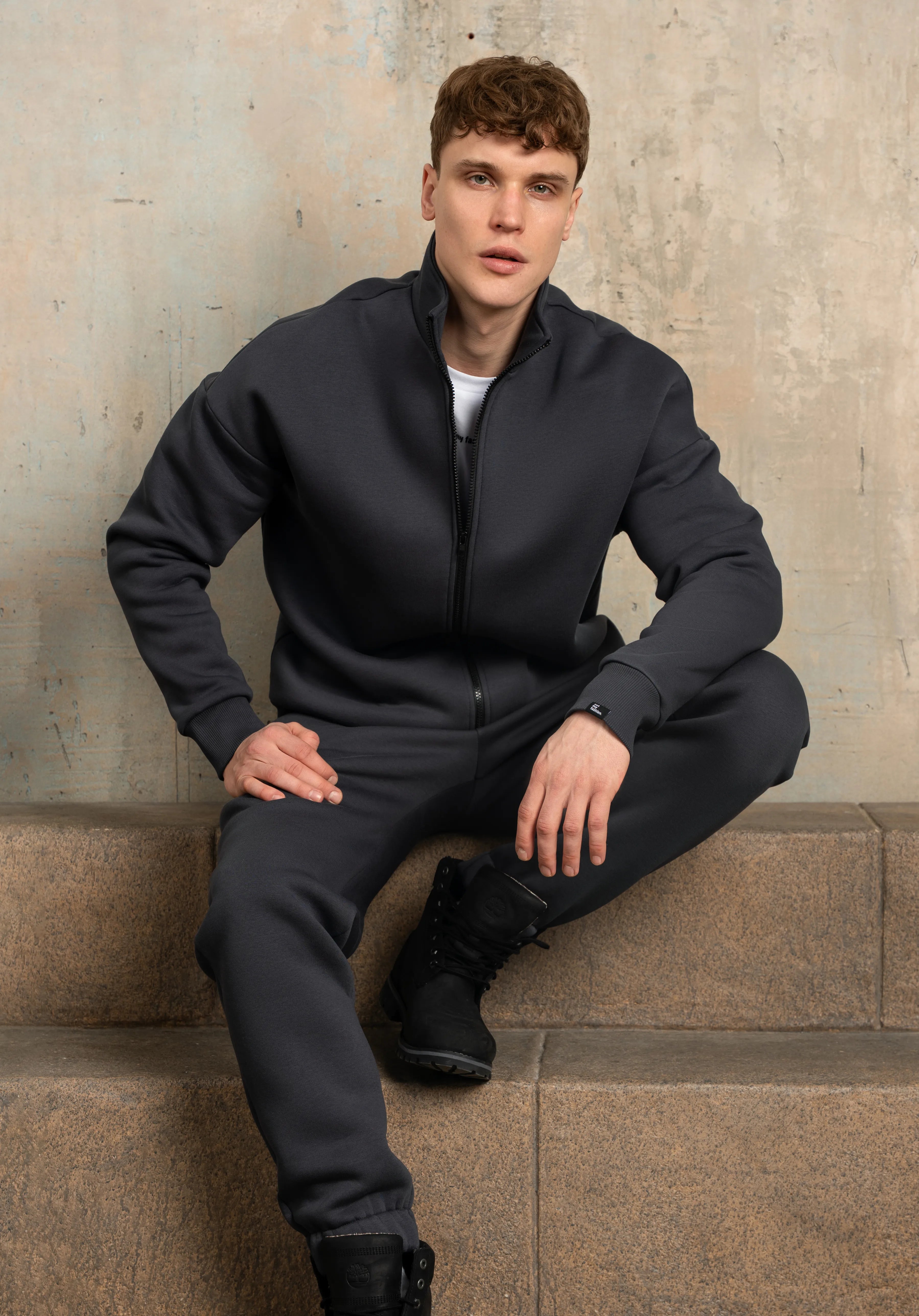 Tamsiai pilkas laisvalaikio treningas su suraukta kelnių apačia, patogus kasdieniam dėvėjimui.