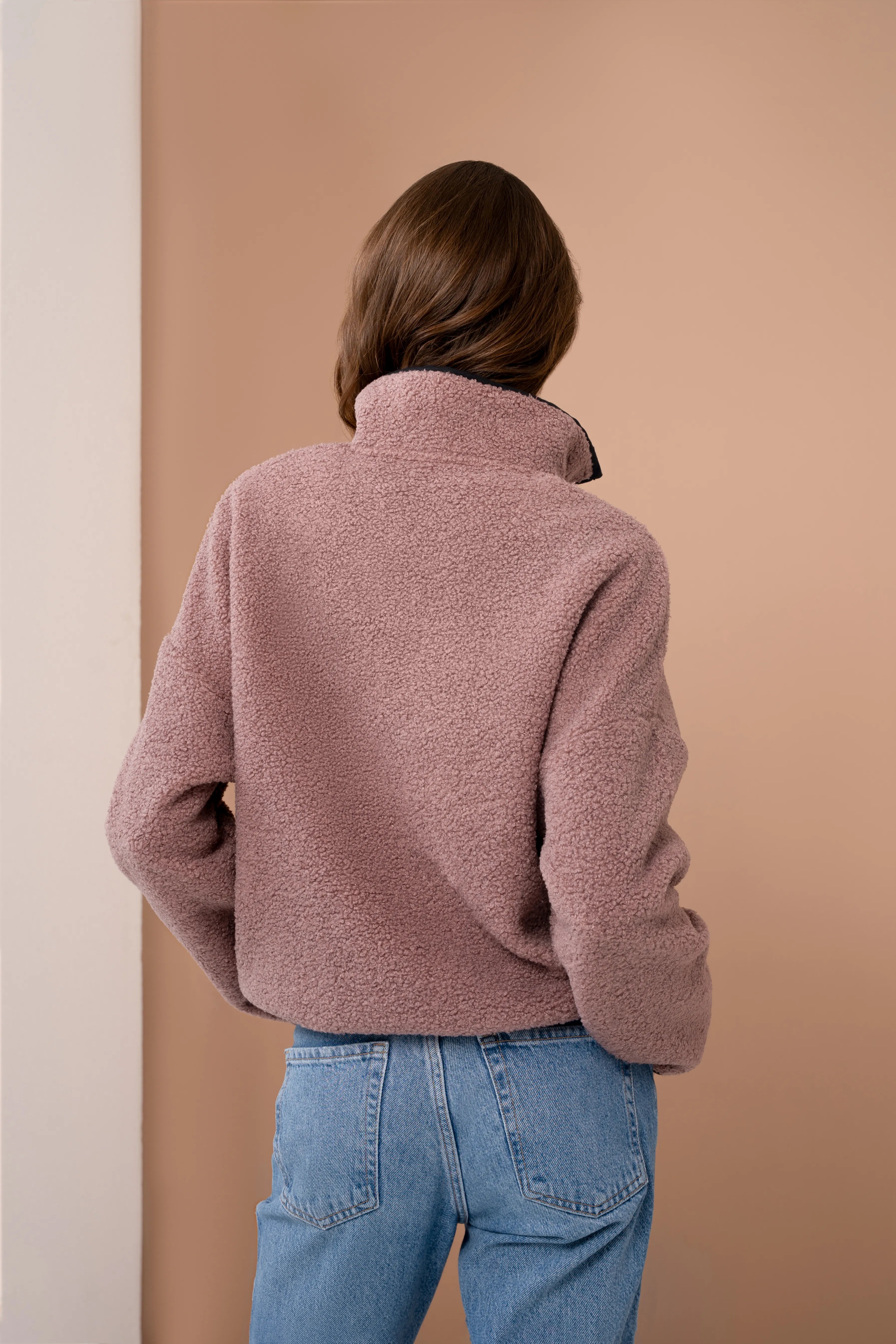 Pink women’s sweatshirt from the back with a stand-up collar, long sleeves, and a straight back line