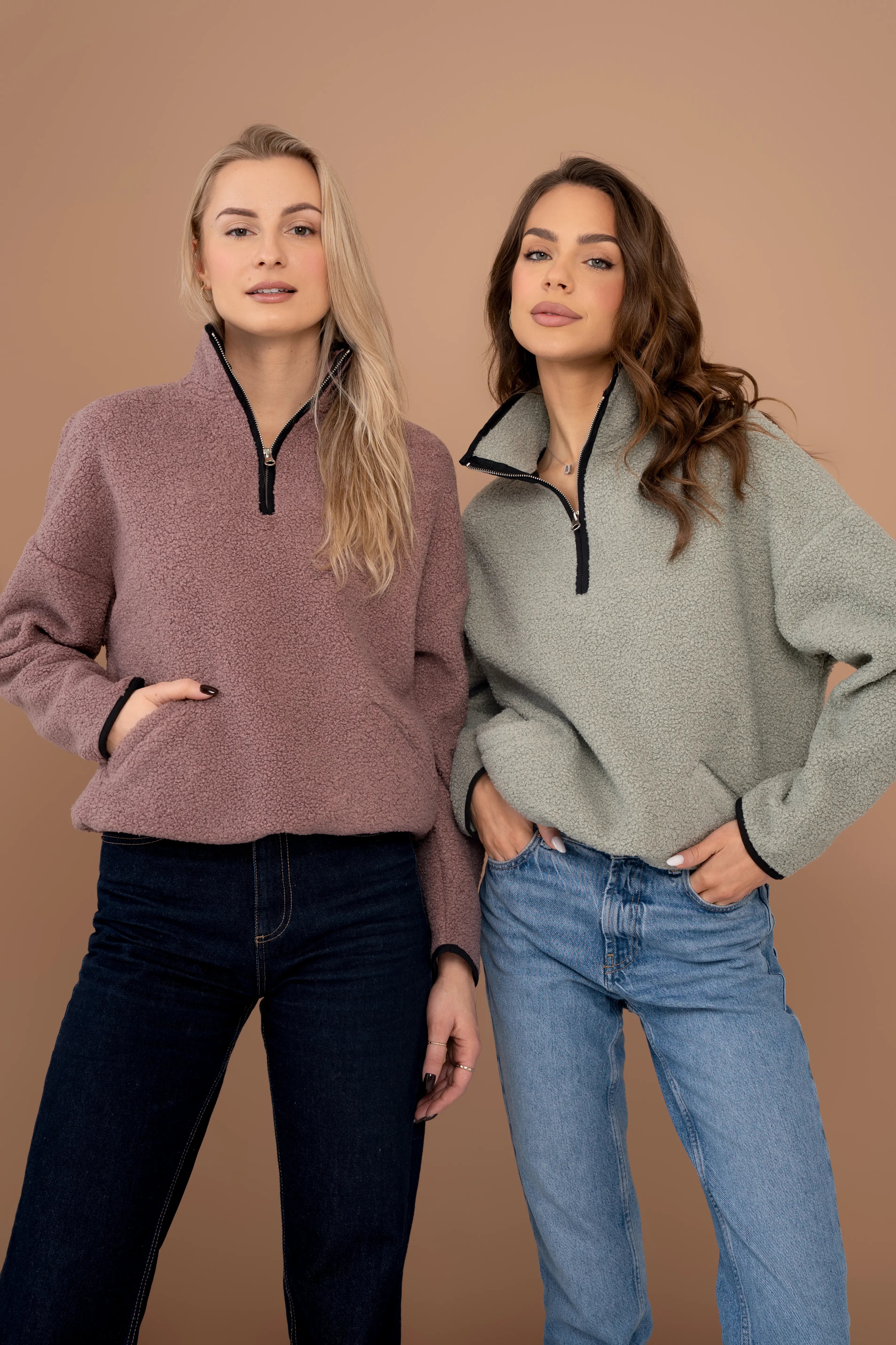 Pink women’s sweatshirt with a short zipper, a stand-up collar, long sleeves, and front pockets